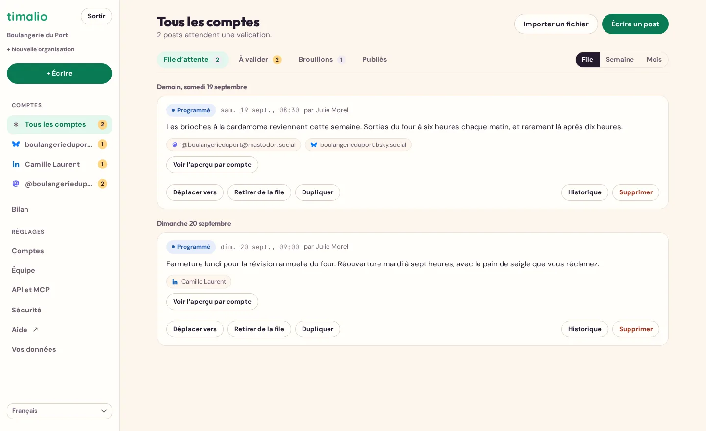 La file de publication de Timalio, découpée par journée : deux posts programmés, leurs comptes visés, les onglets File d’attente, À valider, Brouillons et Publiés, et les vues File, Semaine et Mois.